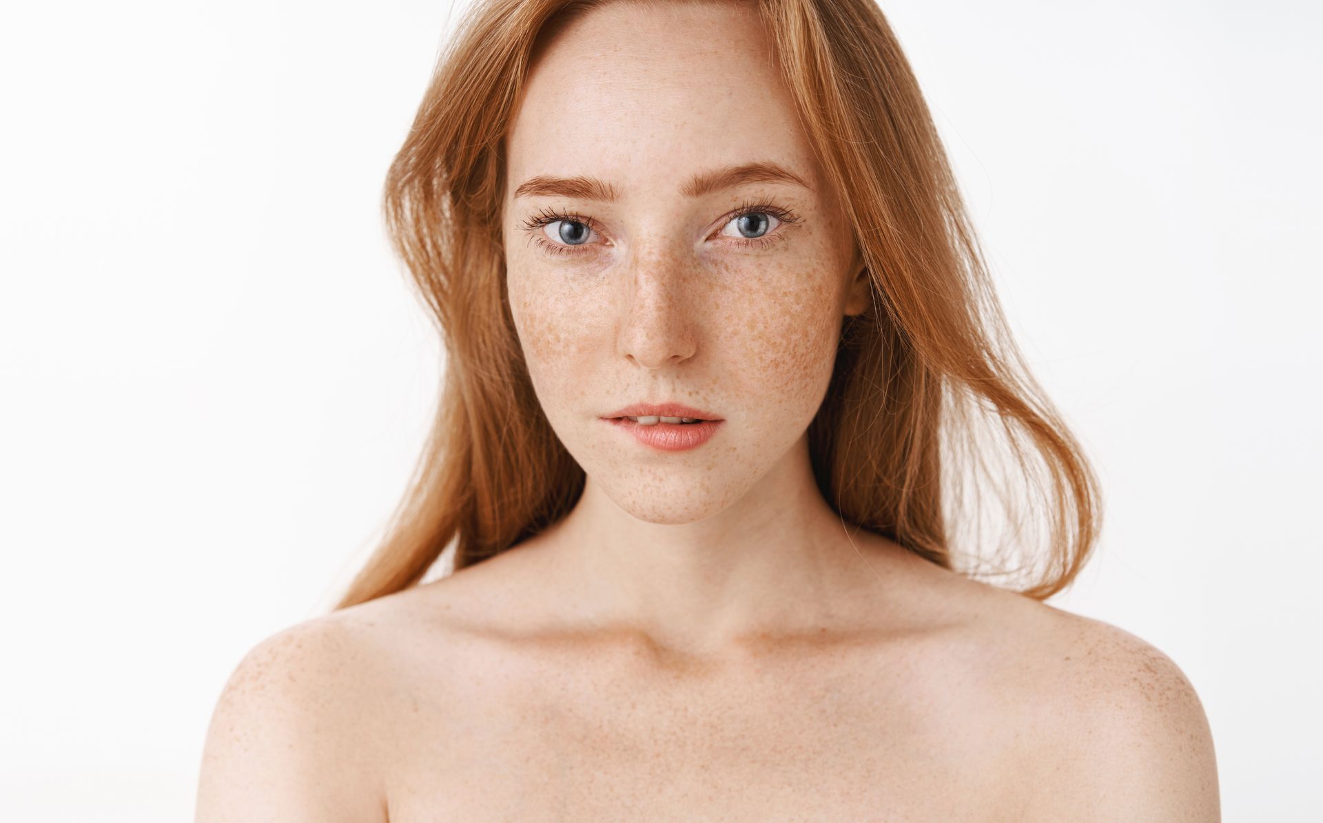 Portrait of a red-haired person with a neutral expression against a white background