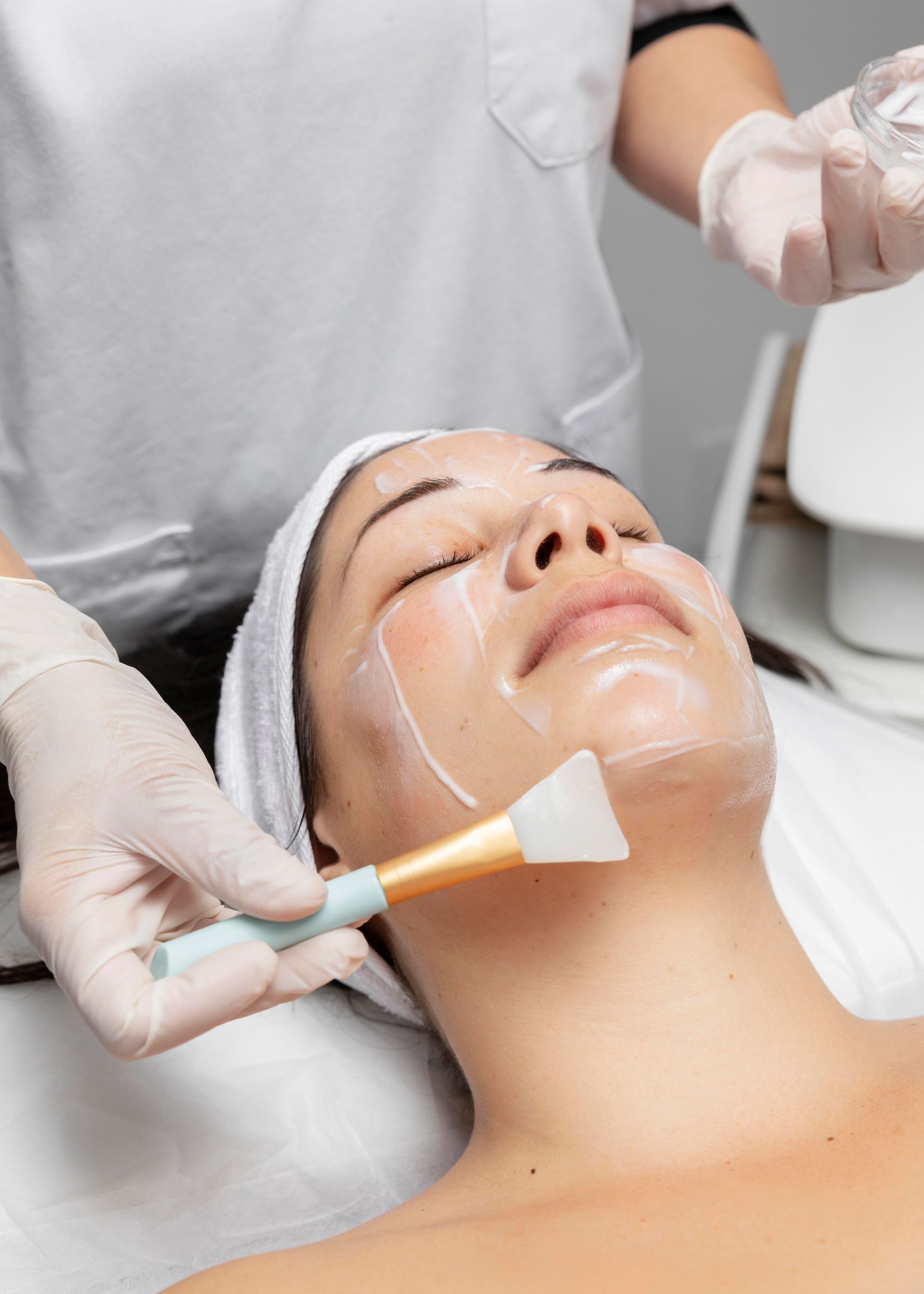 Facial treatment being applied with a brush in a spa setting