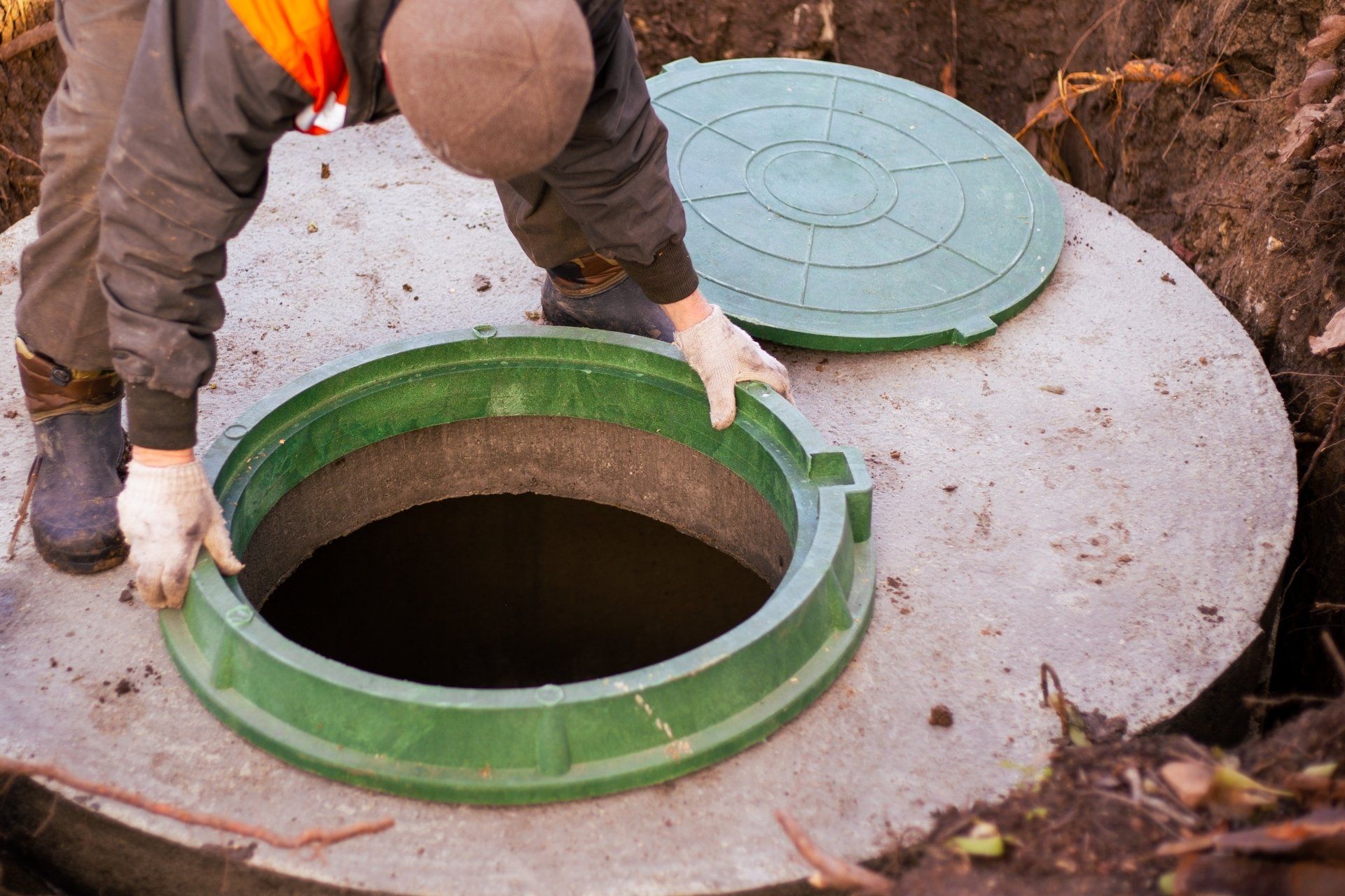 the builder installs a manhole on a concrete sewer well.