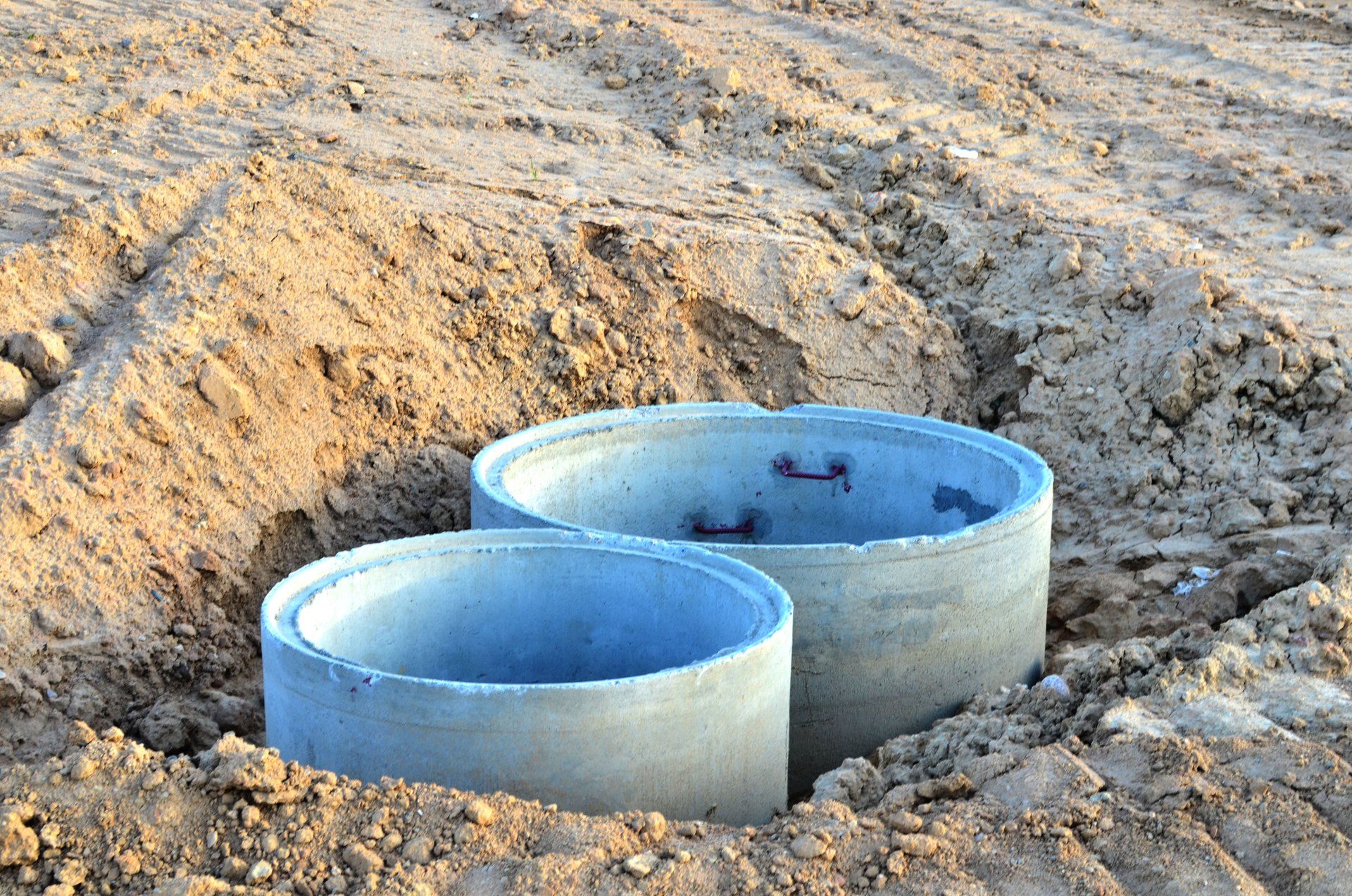 Installation of concrete sewer wells in the ground at the construction site