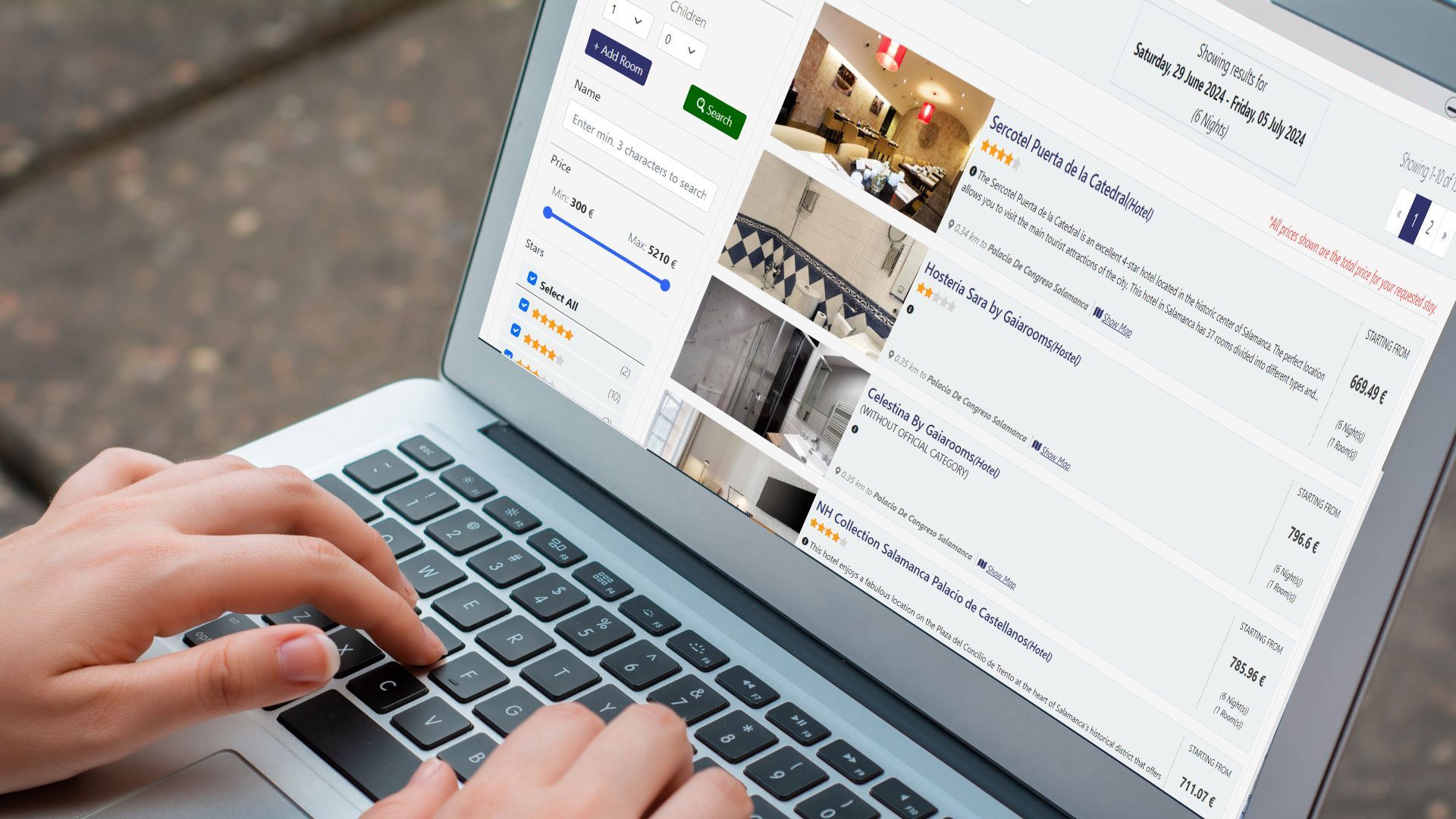 Person typing on a laptop, browsing a hotel booking website with room photos.