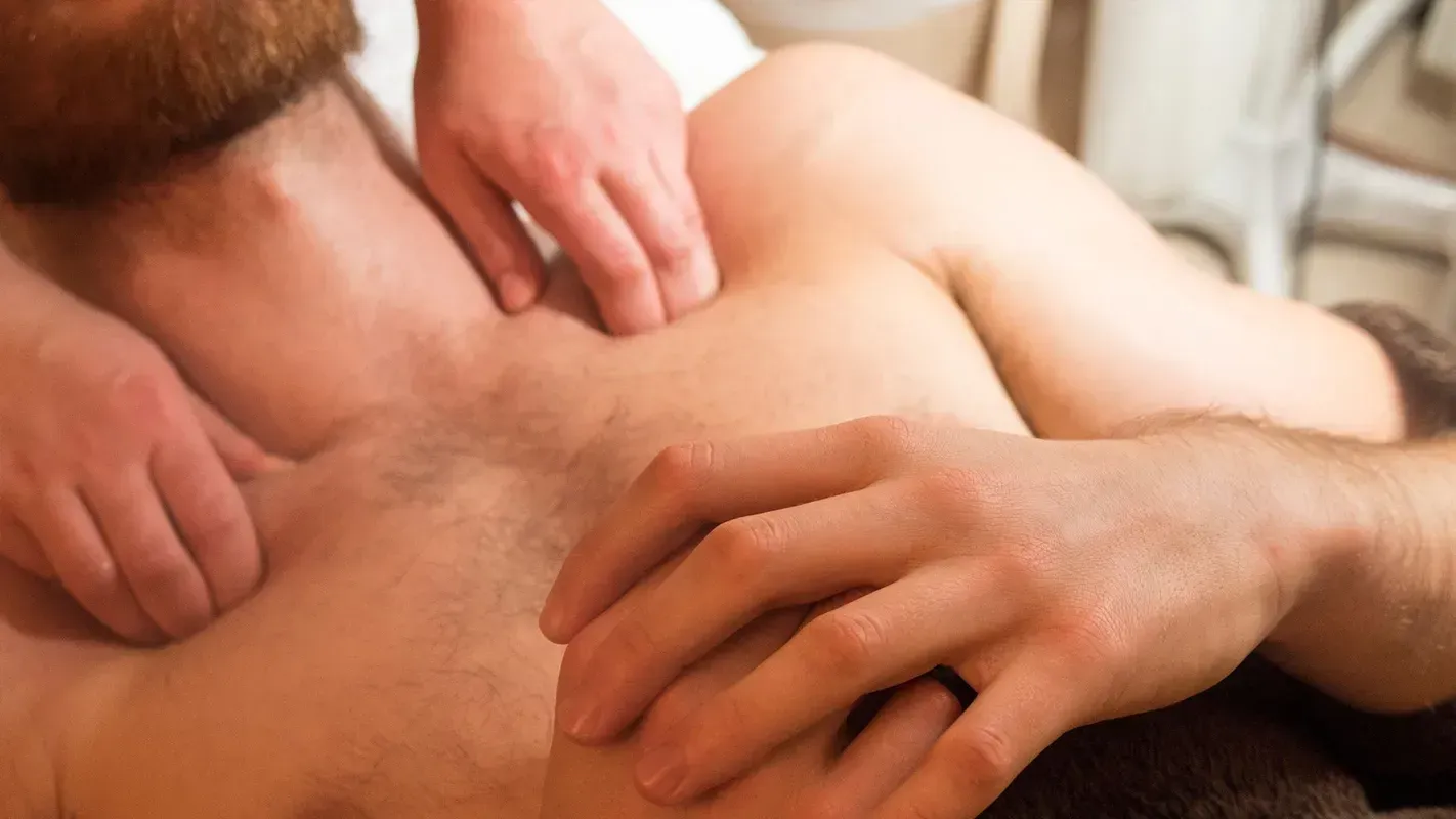 A man is getting a massage from two people.