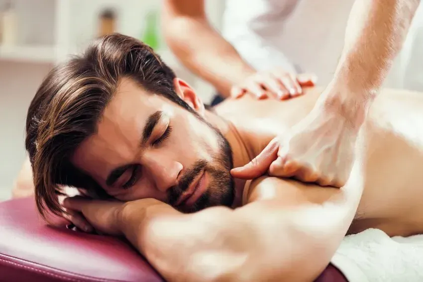 A man is laying on a table getting a massage.