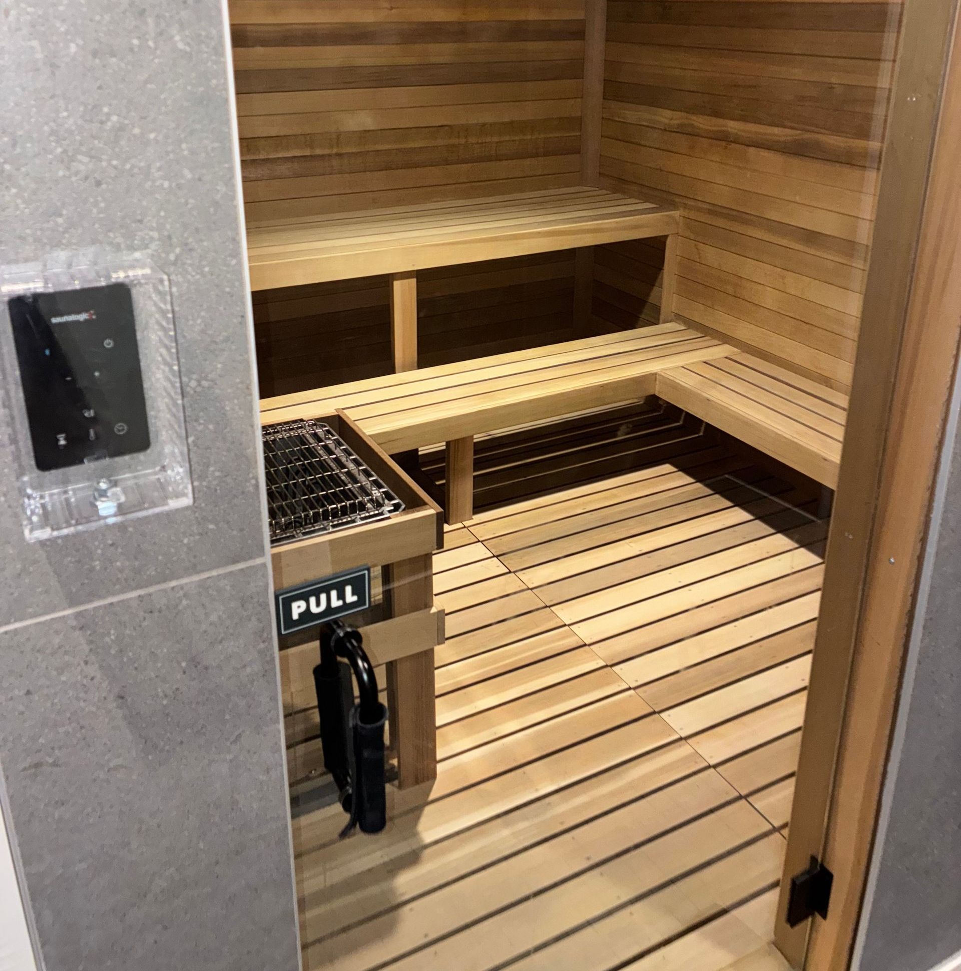 A wooden sauna with a pull sign on the door