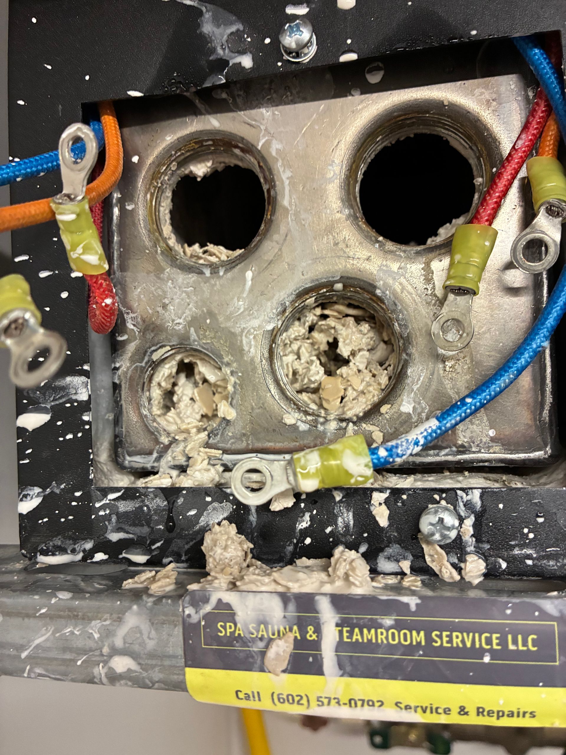 A dirty electrical box with a sign that says steamroom service llc