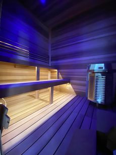 A wooden sauna with blue lights on the walls.