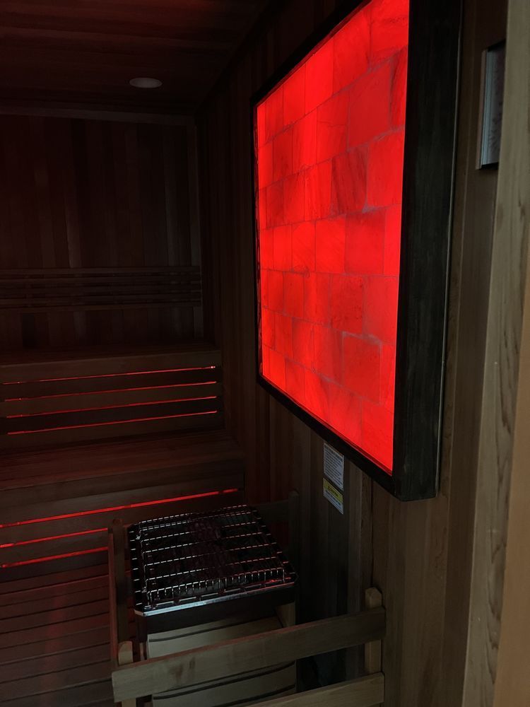 A wooden sauna with a red light on the wall.