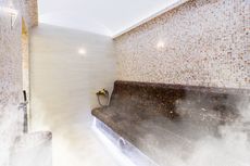 A steam room with a bench and smoke coming out of it.