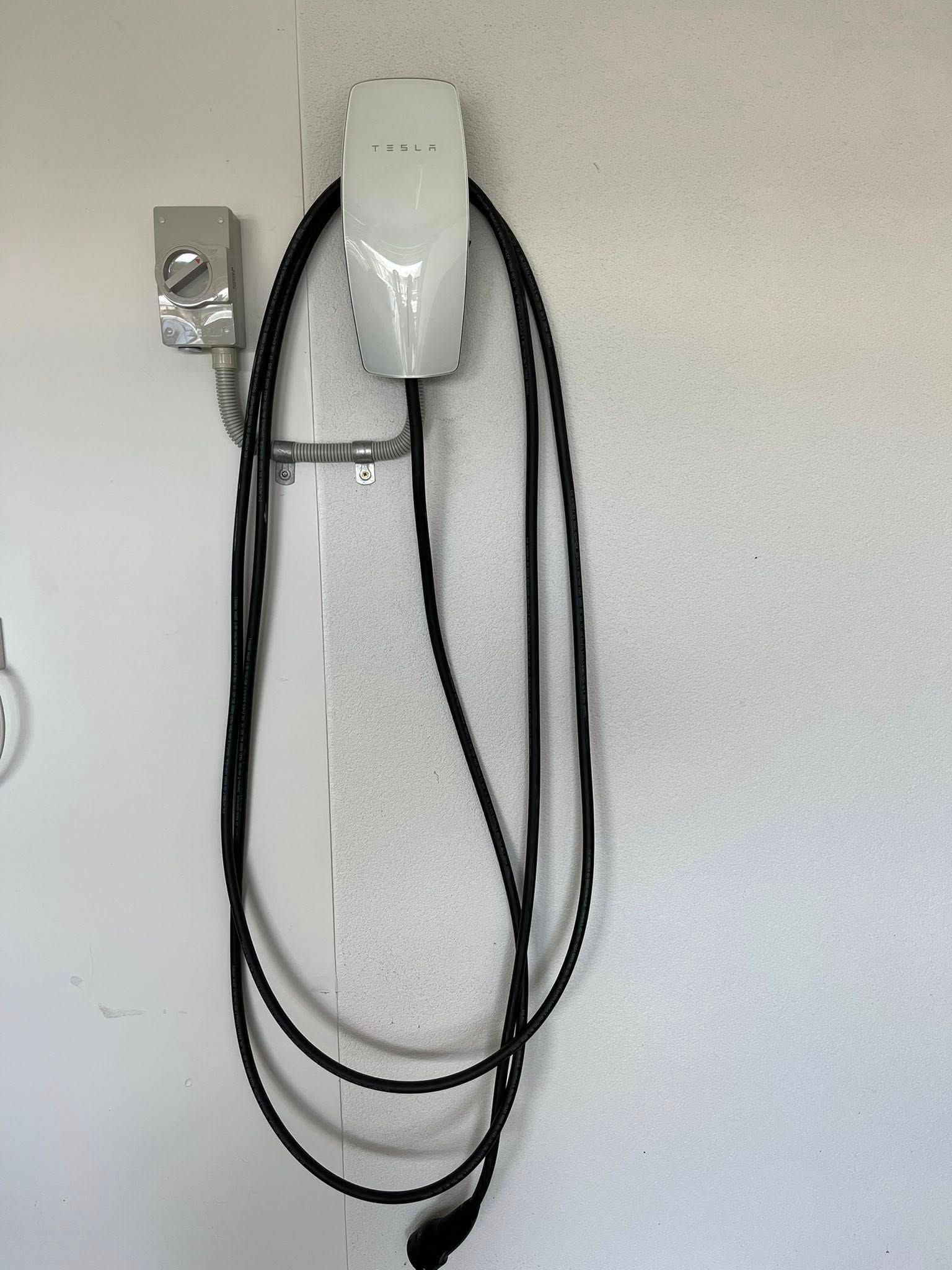 Wall-mounted White Device With Hanging Black Cords — Topspark Electrical FNQ in Mission Beach, QLD