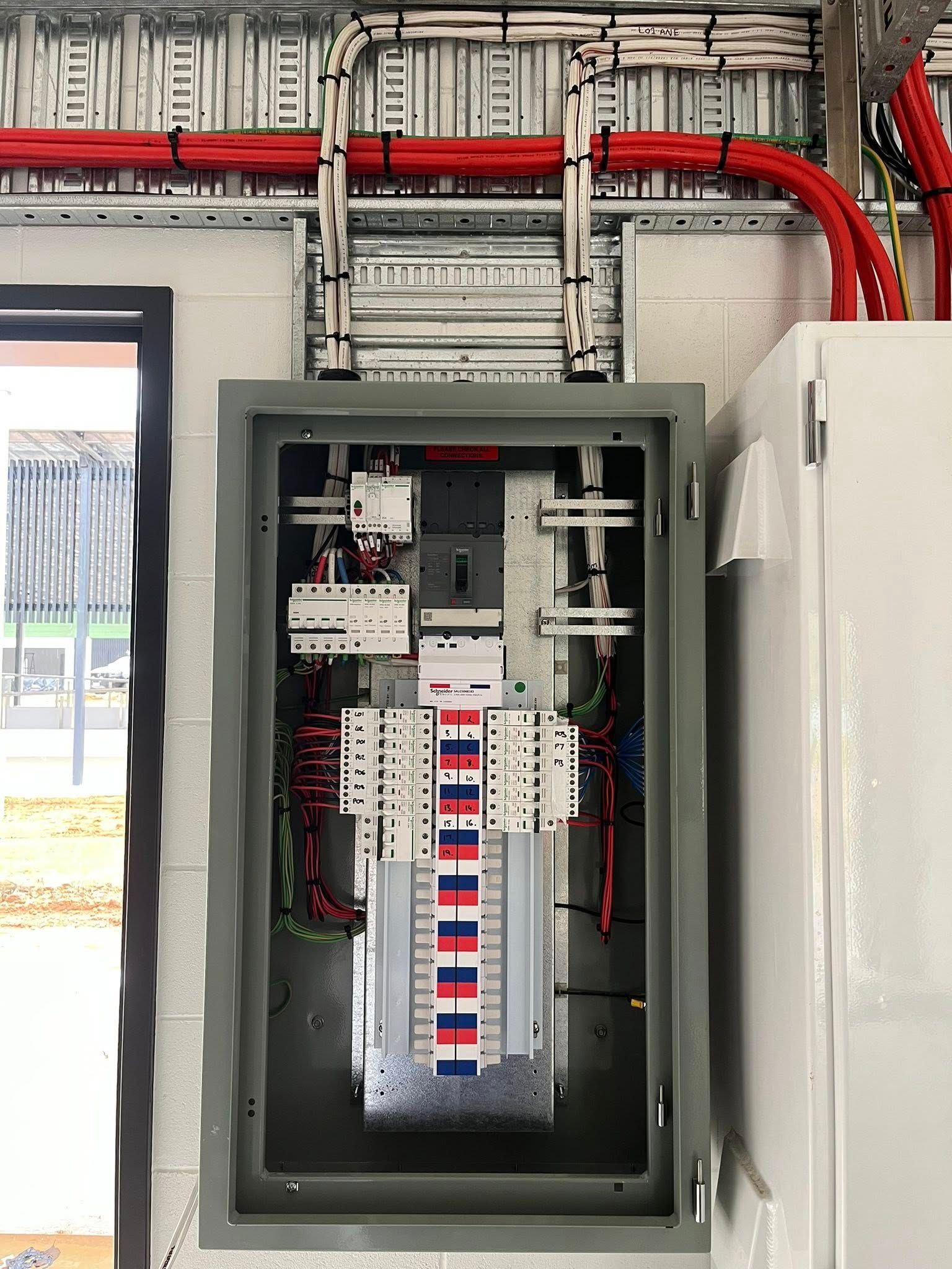 Gloved Hands Working on Electrical Control Panel With Relays and Wiring — Topspark Electrical FNQ in Mareeba, QLD