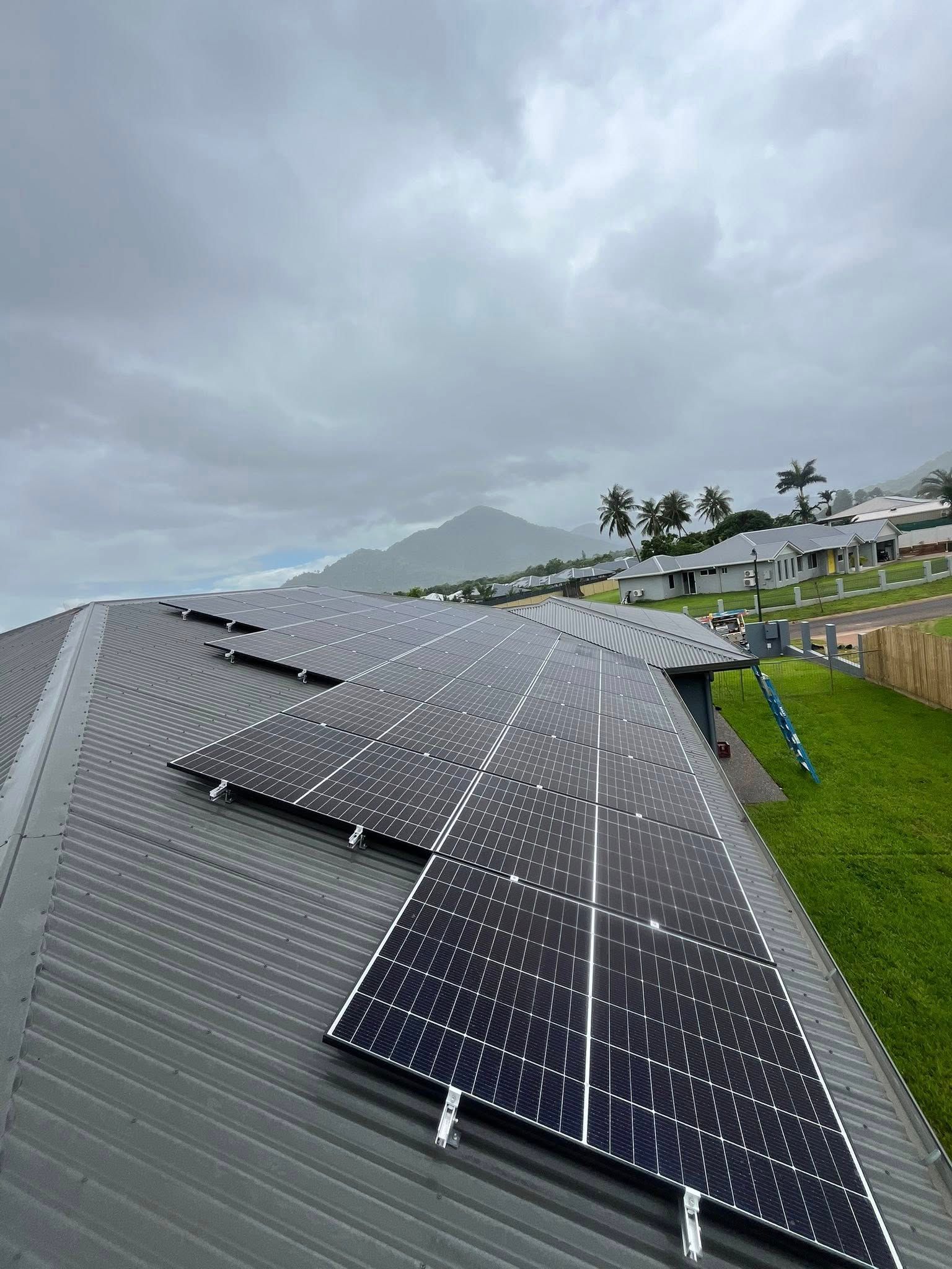 Solar Panels on a Rooftop Under Cloudy Skies — Topspark Electrical FNQ in Innisfail, QLD