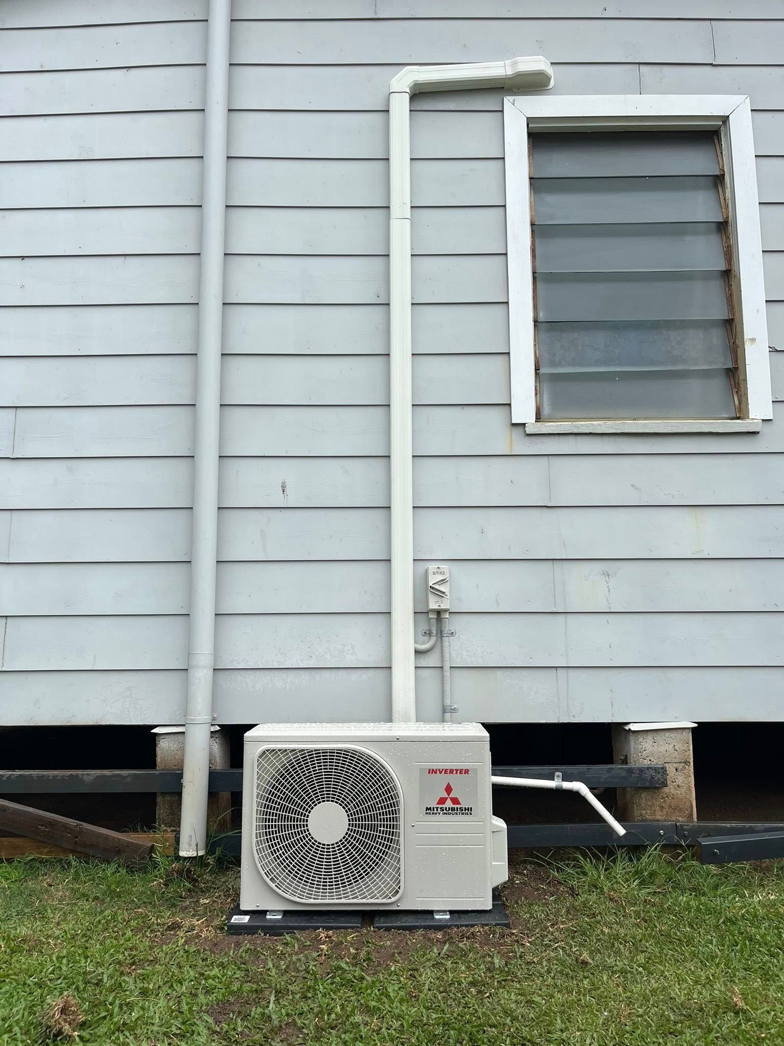 A House With a White Pipe, and Air Conditioning Unit on the Ground — Topspark Electrical FNQ in Innisfail, QLD