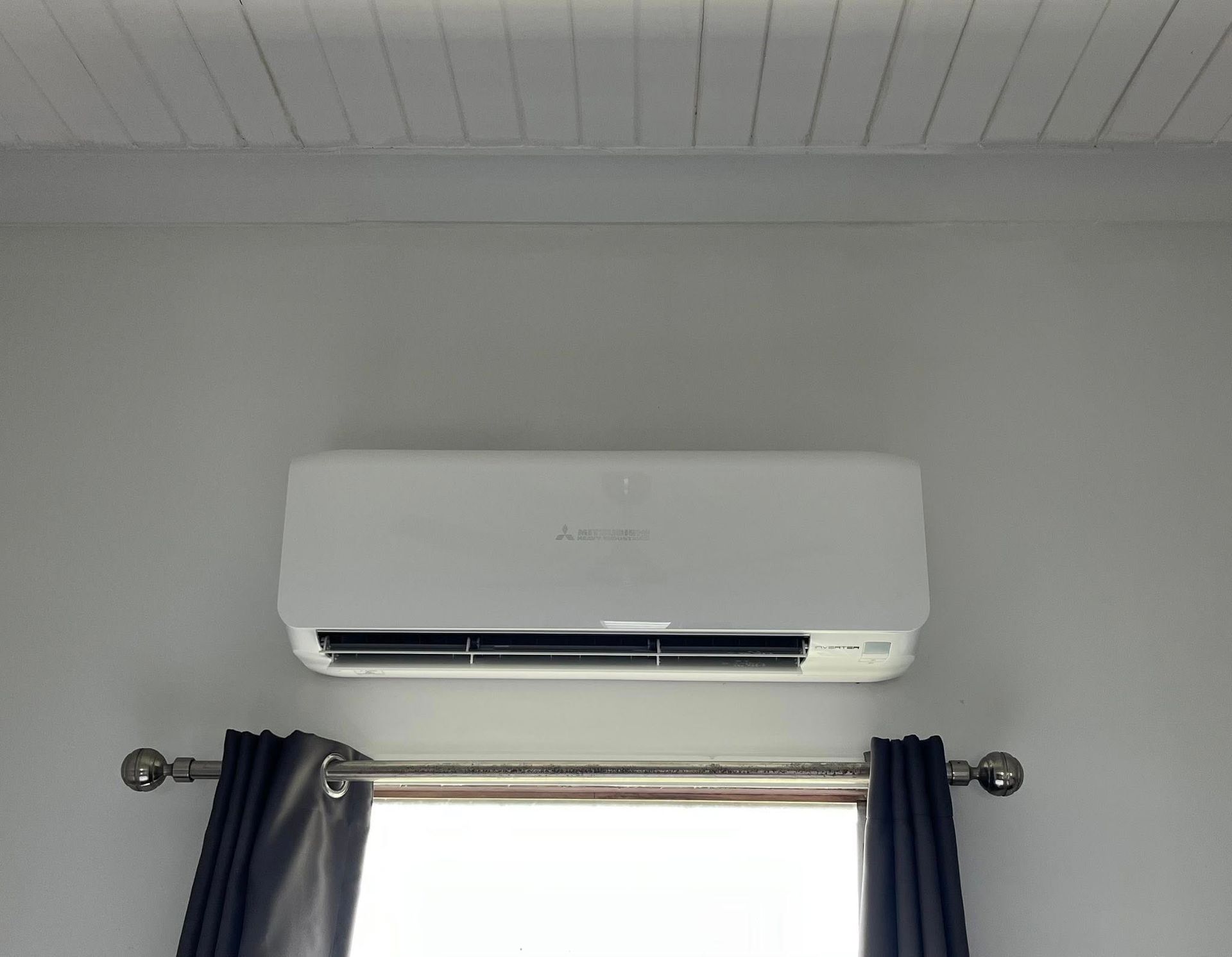 White Wall-mounted Air Conditioner Above a Window — Topspark Electrical FNQ in Malanda, QLD