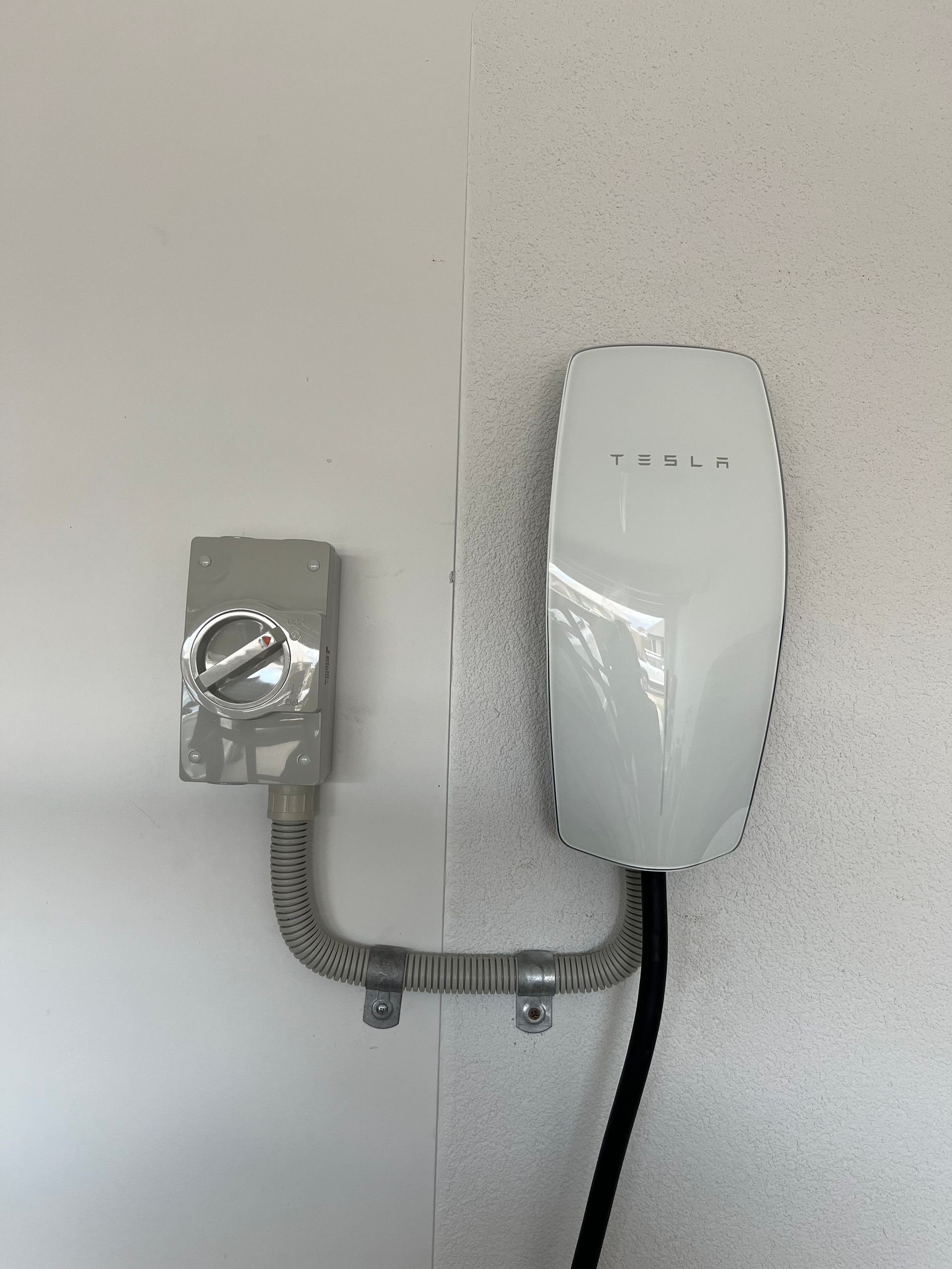 Technician Adjusting a Wall-mounted Ev Charger — Topspark Electrical FNQ in Malanda, QLD