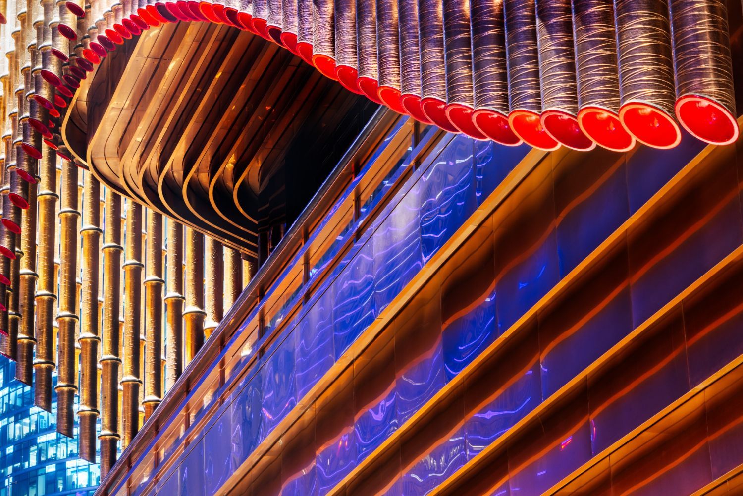 Aufwendig verzierte Orgelpfeifen mit roten Akzenten, goldenem Holz und blauer Beleuchtung.
