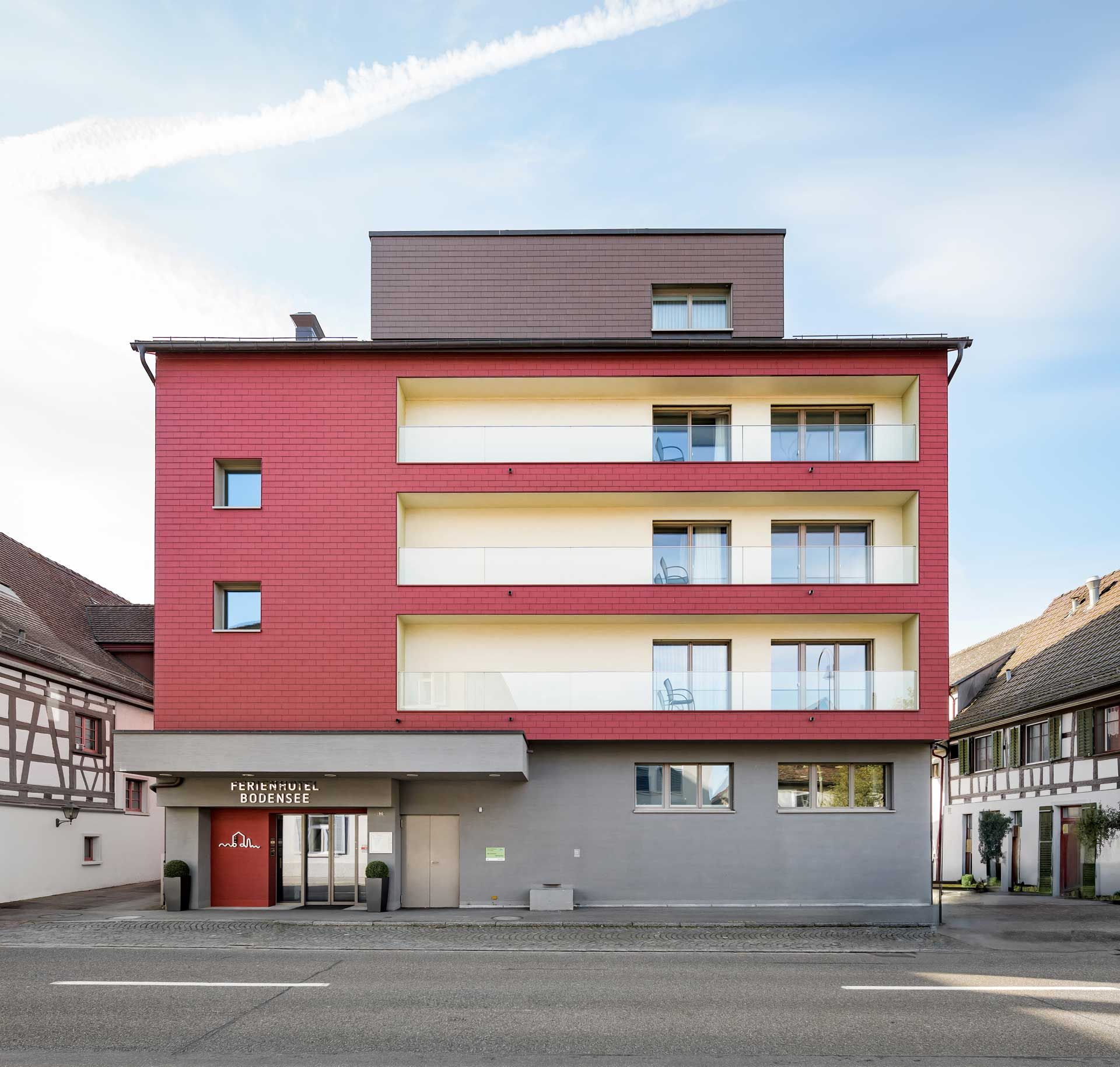 Ein großes rot-weißes Gebäude mit einem Balkon