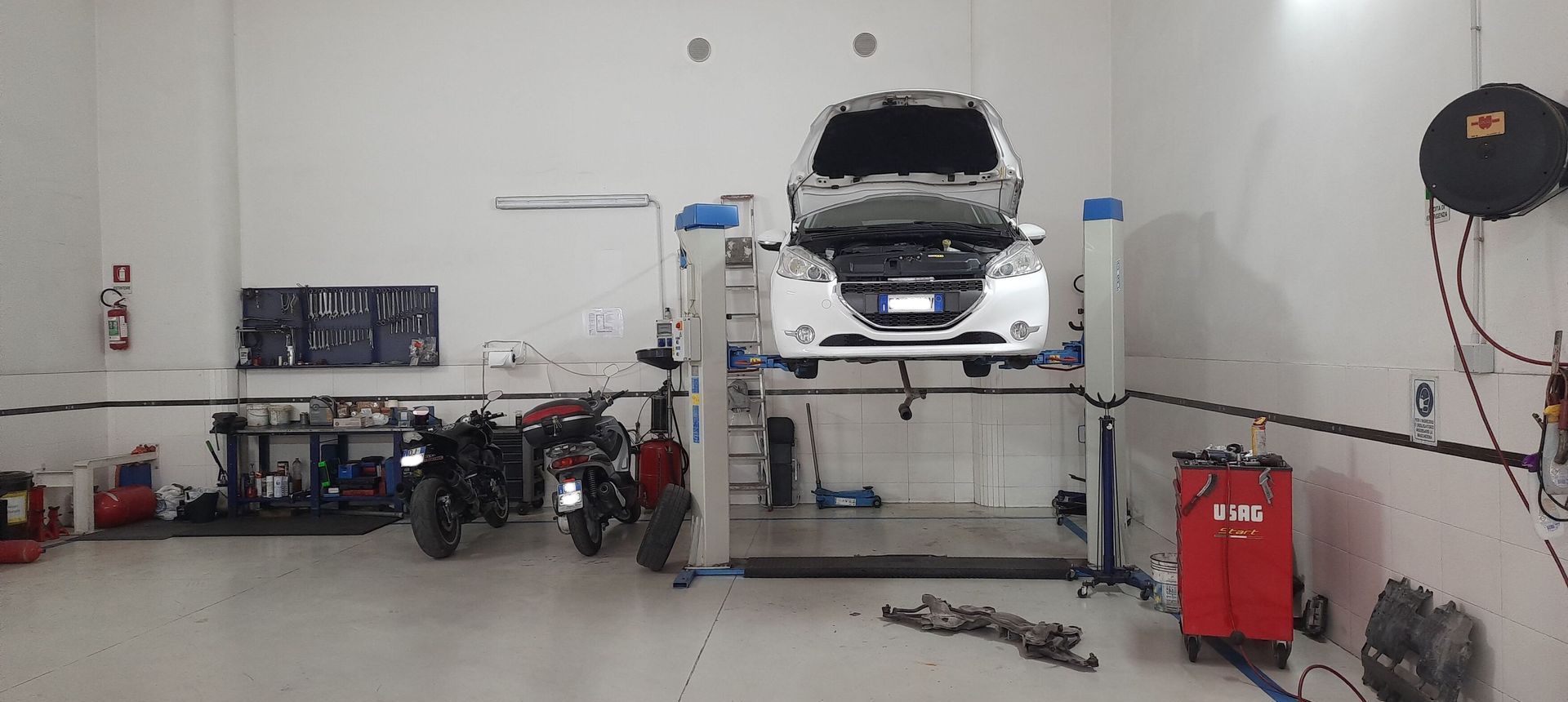 Un'auto è parcheggiata su un ponte sollevatore in un garage.