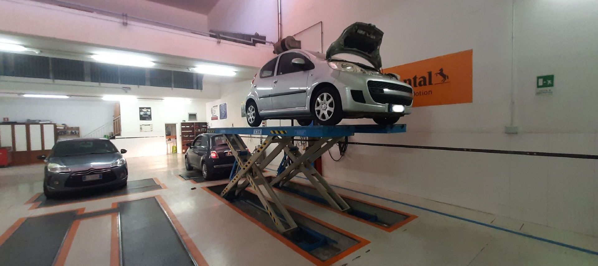 Un'auto è parcheggiata su un ponte sollevatore in un garage.