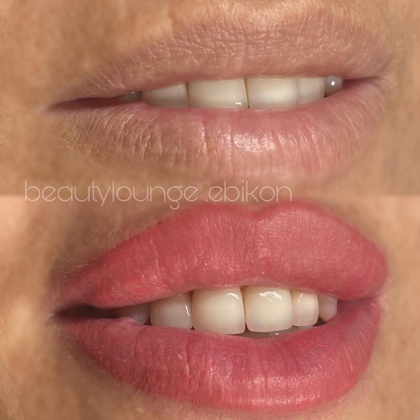 Eine Nahaufnahme der Lippen einer Frau mit rotem Lippenstift und weißen Zähnen.