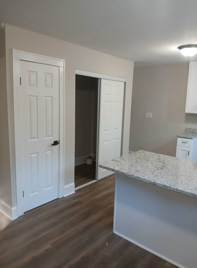 Kitchen with granite countertop, doors, and hardwood floors.