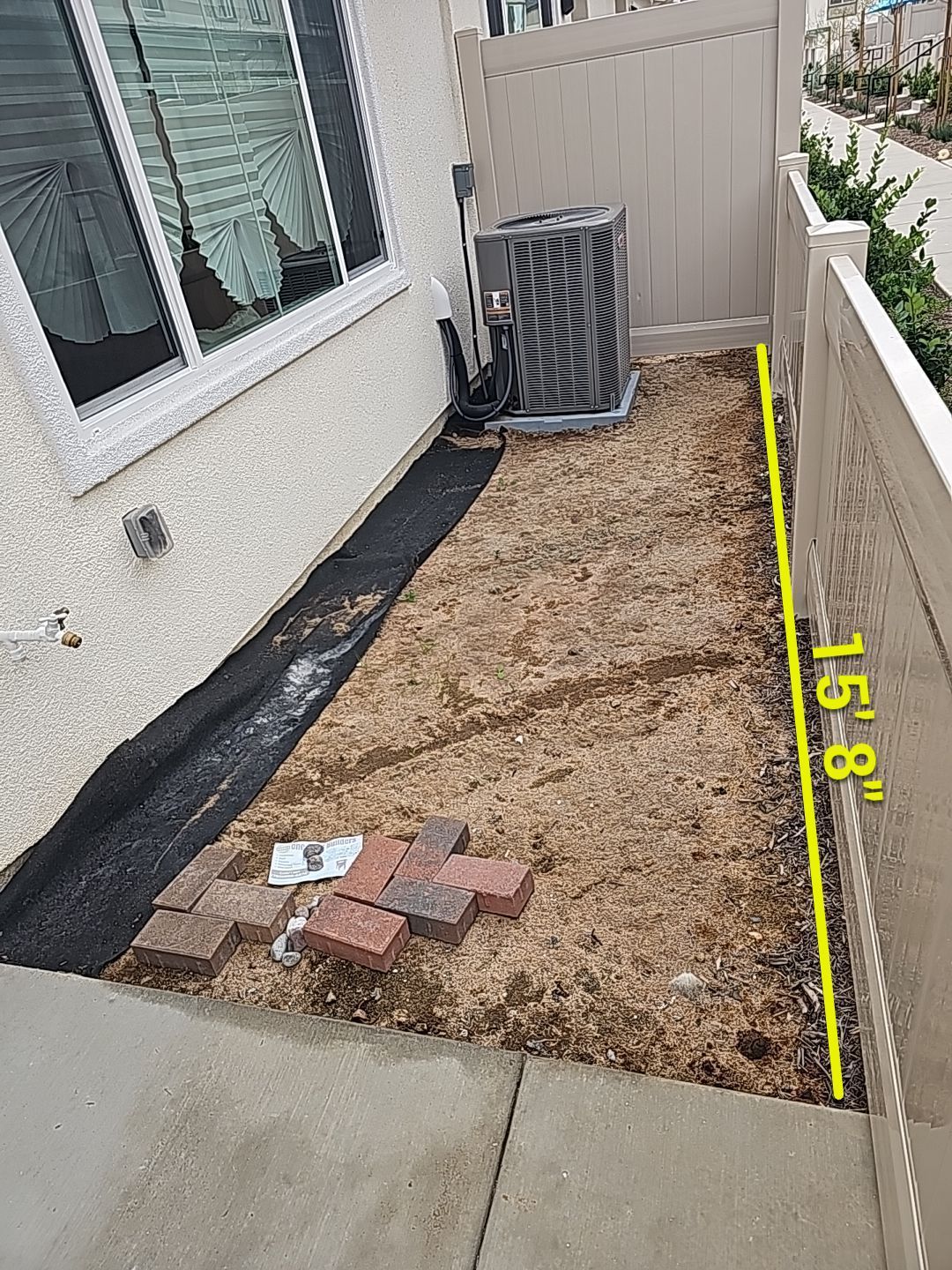 Narrow side yard with an AC unit, fence, and bare earth marked with a 15'8