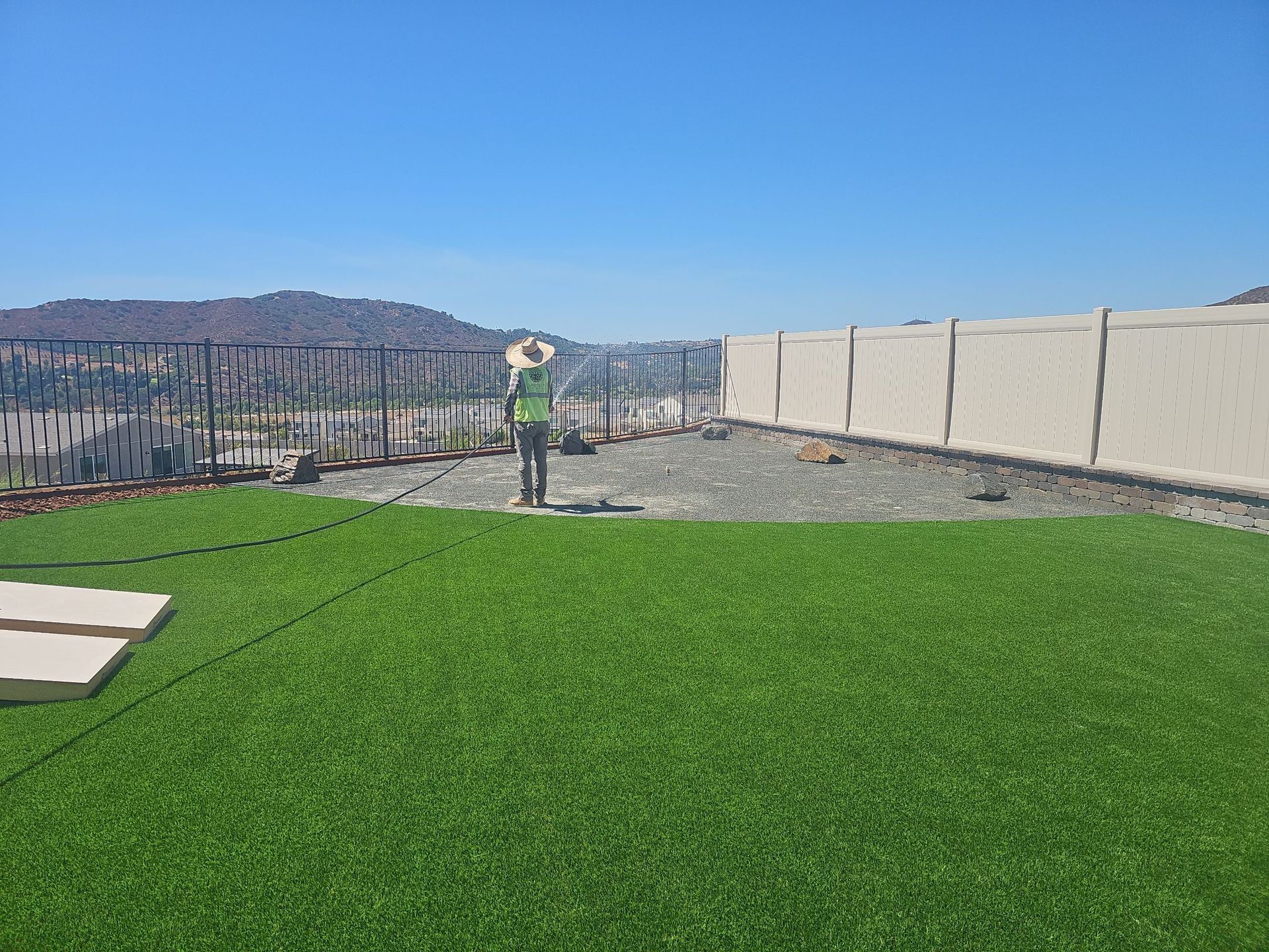 Artificial green turf with a person and cityscape background.