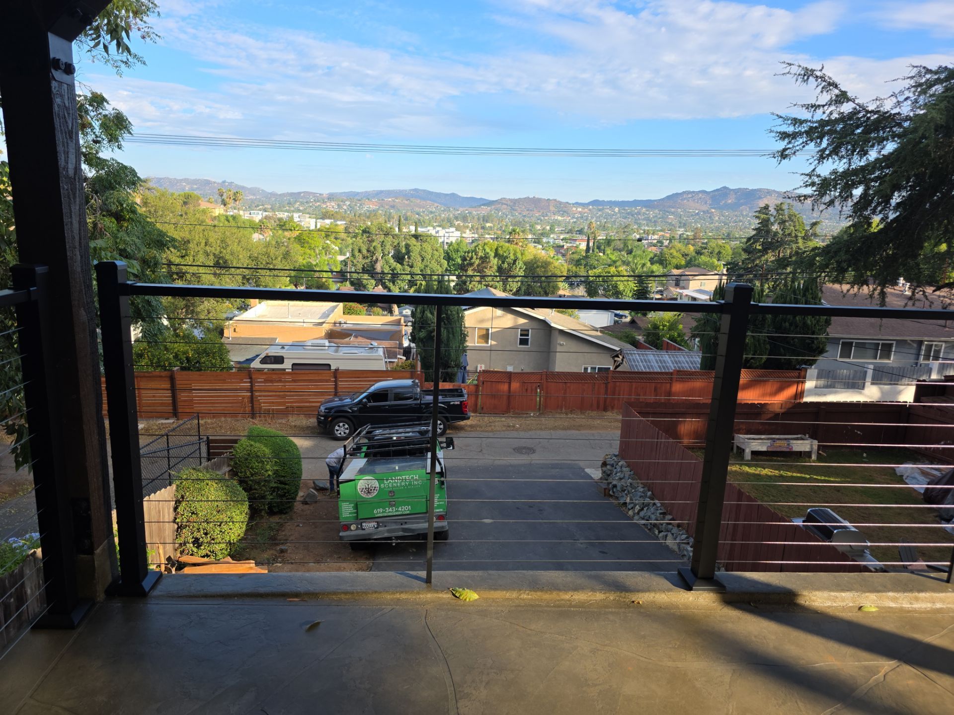 View from a porch overlooking a town with a mountain range in the distance.