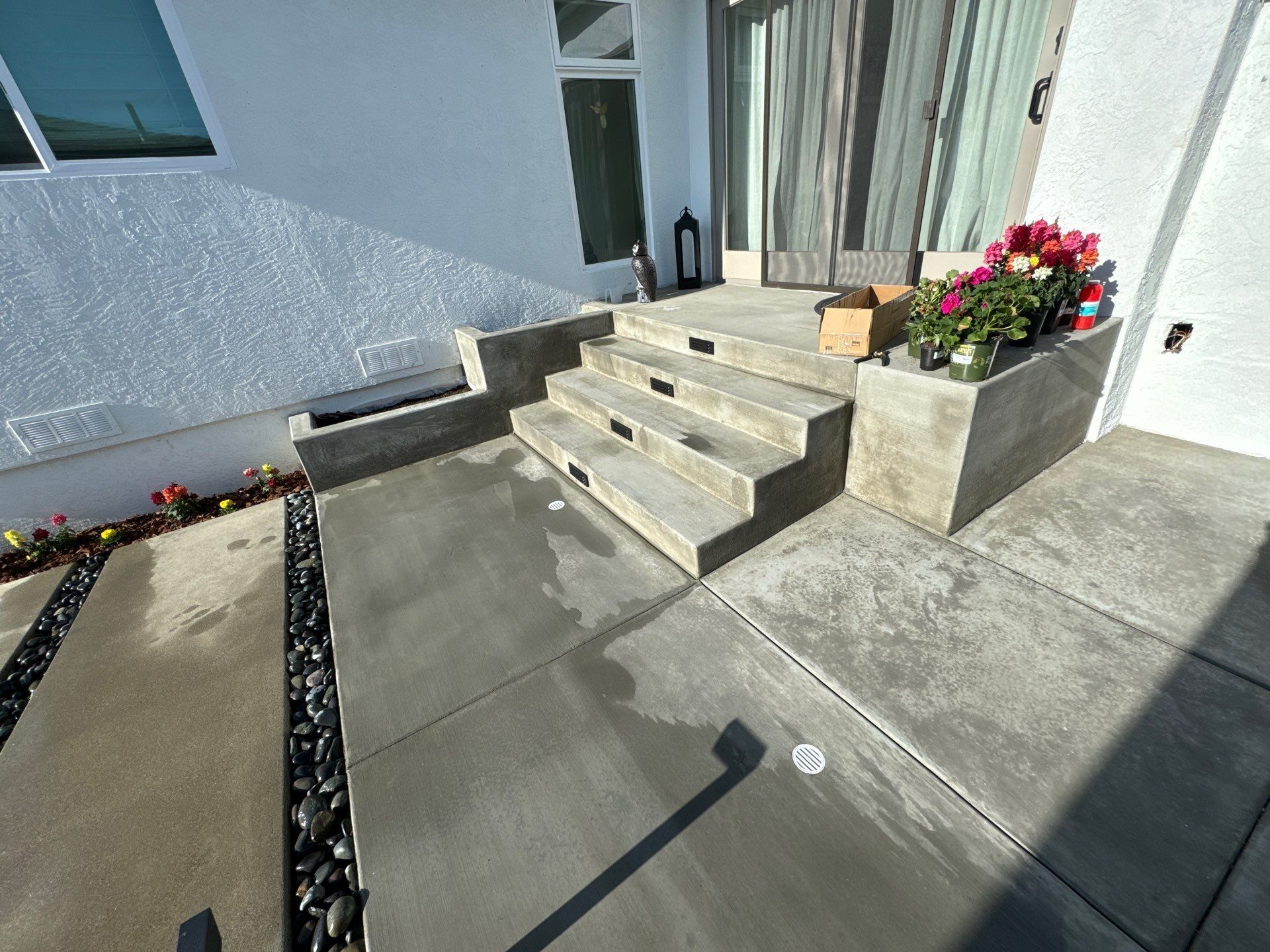 Concrete steps leading up to a house entrance with a flower box.