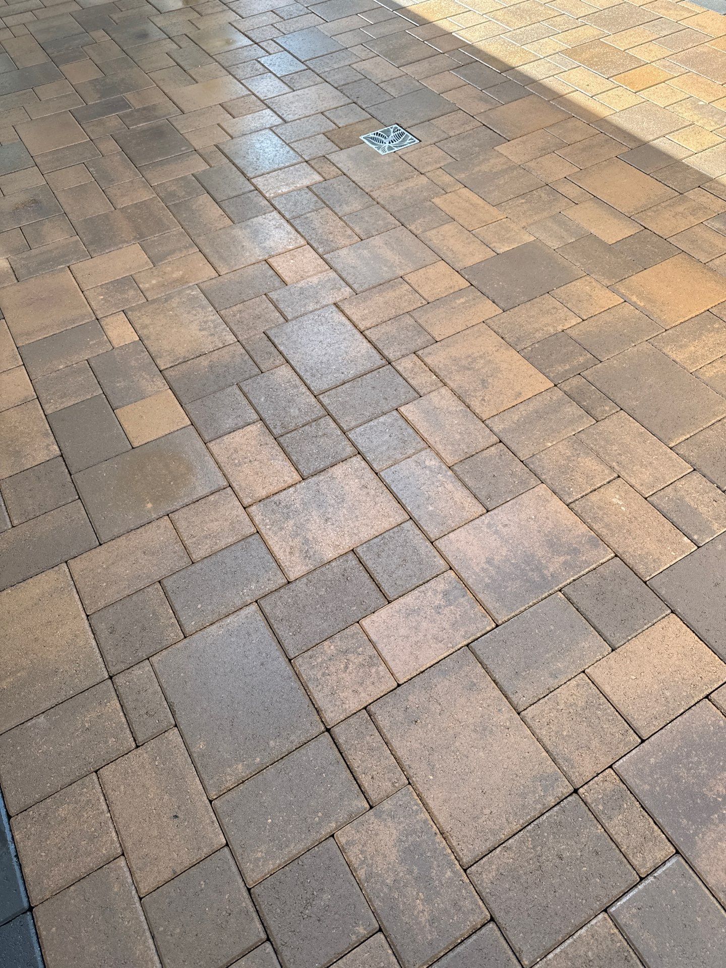 Brick patio with a repeating rectangular pattern in shades of brown and gray.
