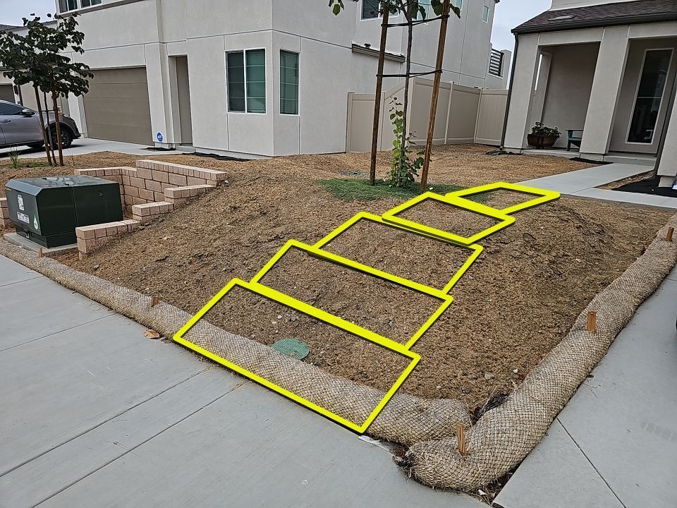 Residential landscaping with mulch and outlined steps.