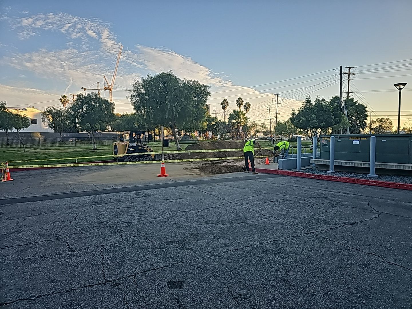 Construction site with workers, equipment, and safety cones.