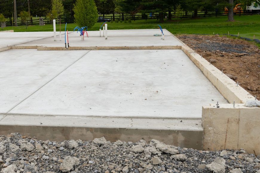 A concrete foundation is being built in a yard