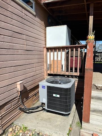 An air conditioner is sitting on the side of a house.