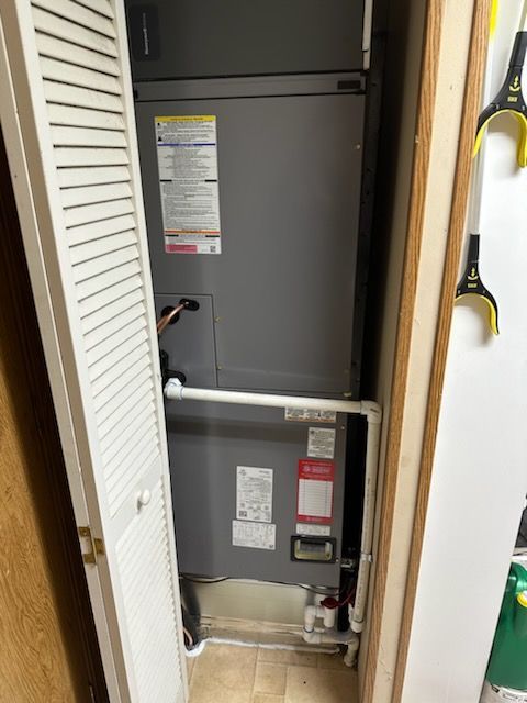 An air conditioner is sitting in a closet next to a door.