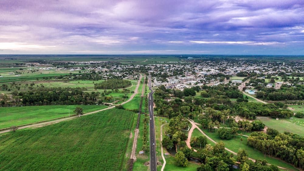 An Aerial View of A Road Going Through a Lush Green Field — Conveyor Maintenance Services In Ayr, QLD