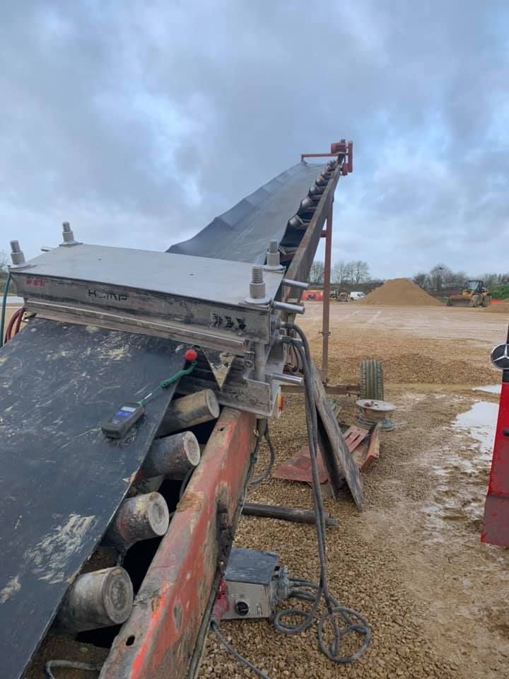 A Conveyor Belt Is Sitting on Top of A Dirt Field — Conveyor Maintenance Services In Proserpine, QLD