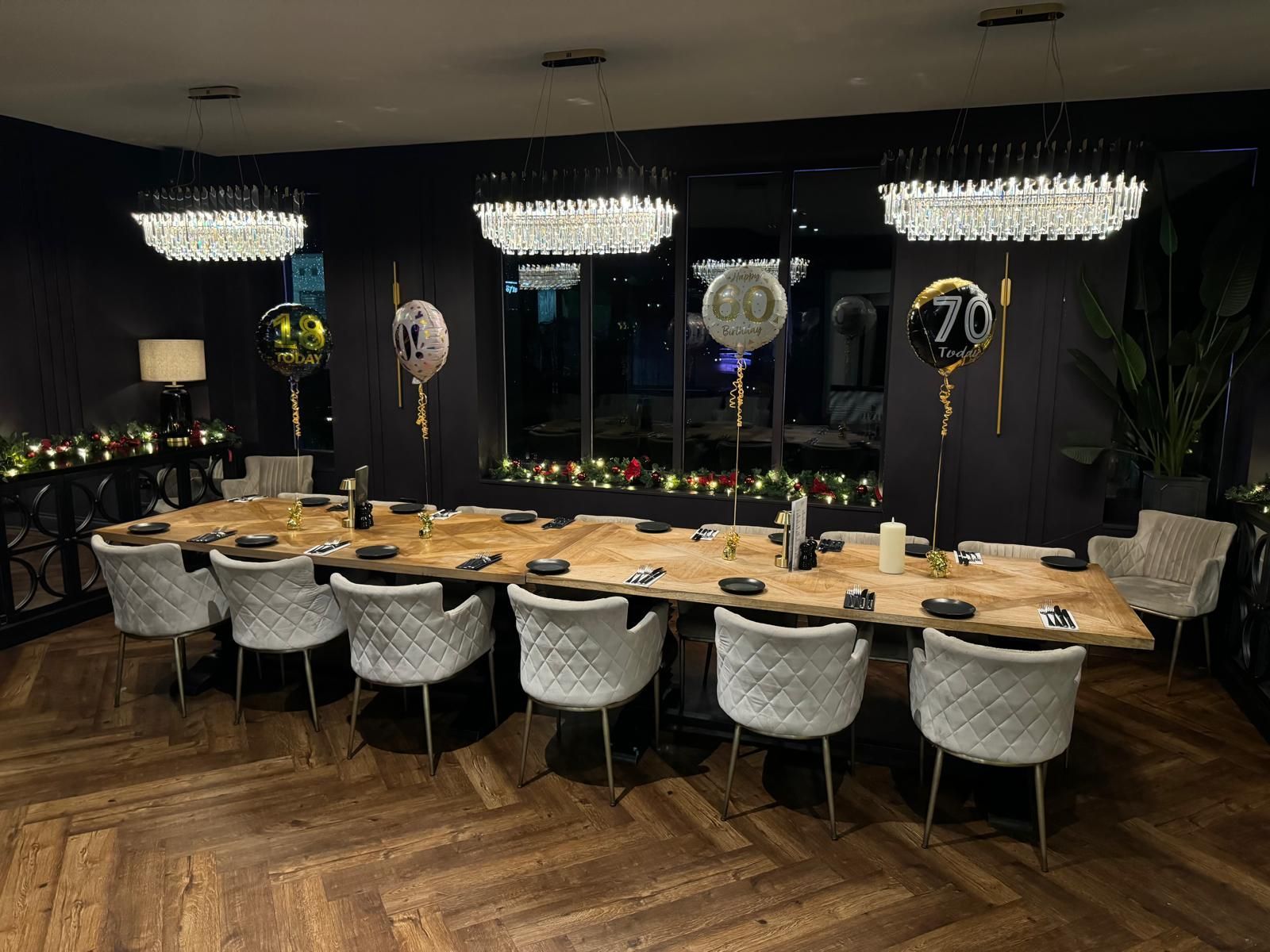 A bar interior with green tile, orange chairs, and hanging lights; liquor bottles on shelves.