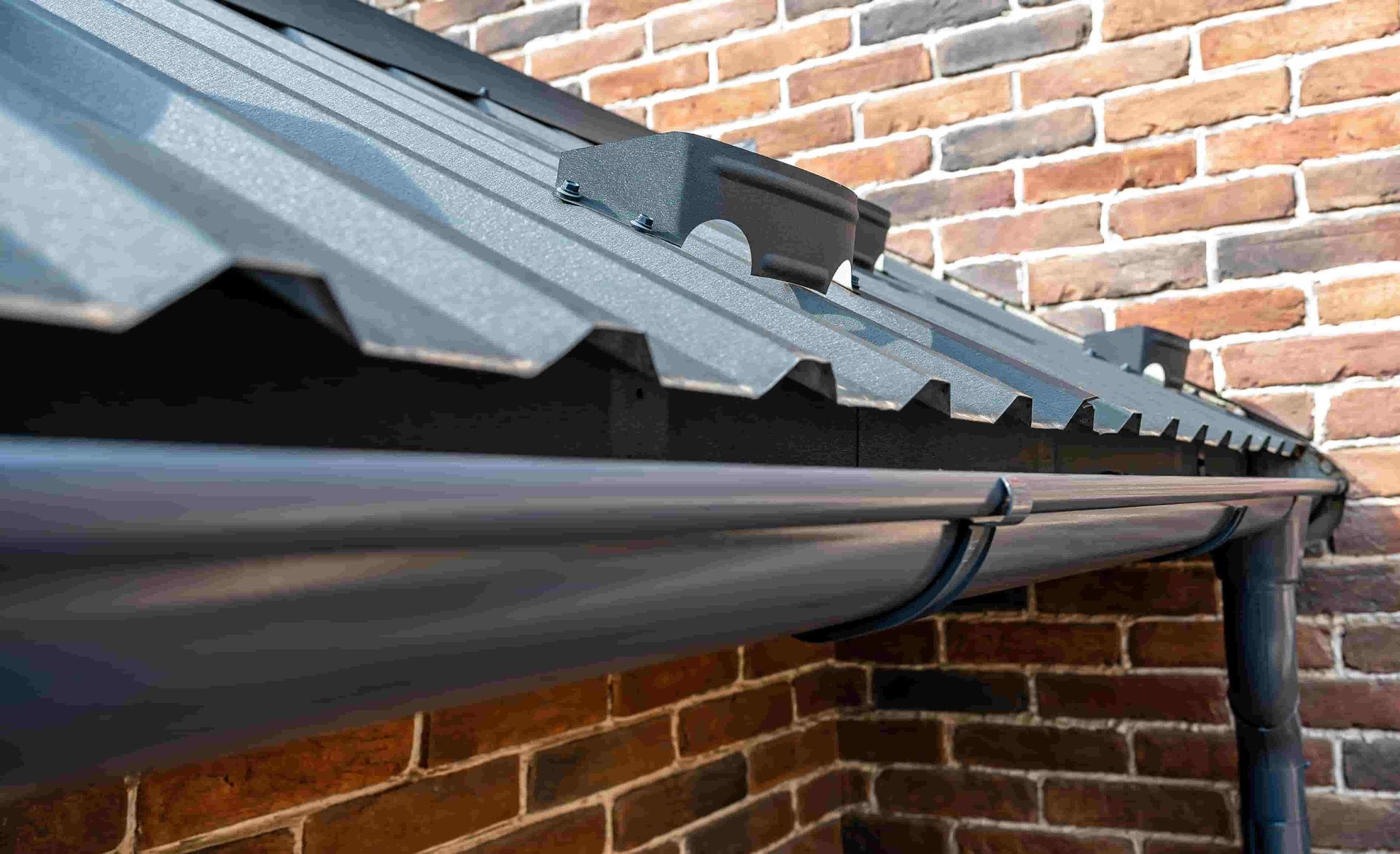 A close up of a gutter on a brick wall — Posty’s Roofing In Airlie Beach, QLD