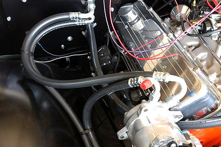 A close up of a car engine with a carburetor.