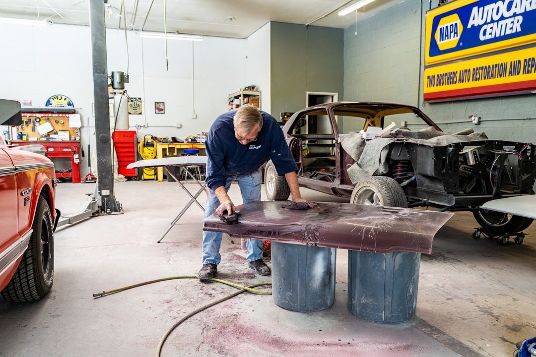 A man is working on a car in a garage.