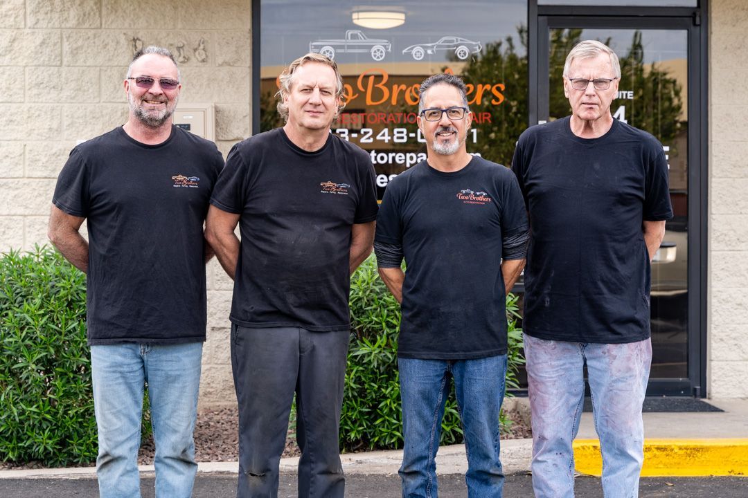 A group of men are posing for a picture in front of a building.