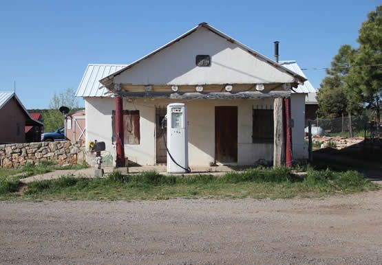 A small house with a gas pump in front of it