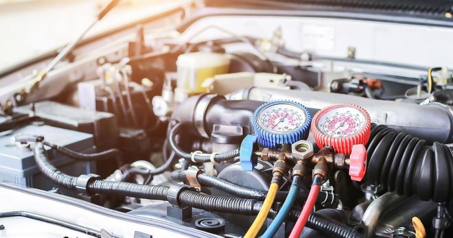 A close up of a car engine with gauges on it.