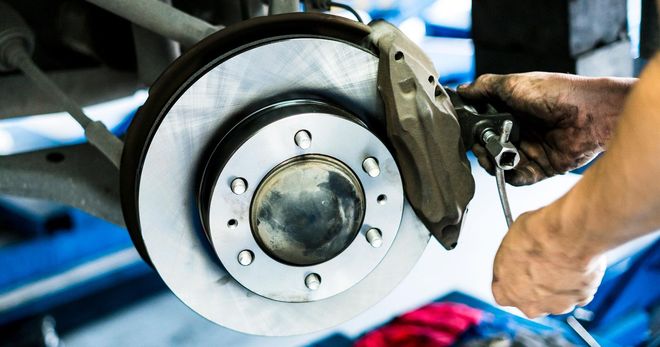 A person is working on a brake disc on a car.