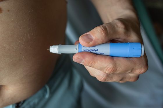 A close up of a person holding a syringe in their hand.