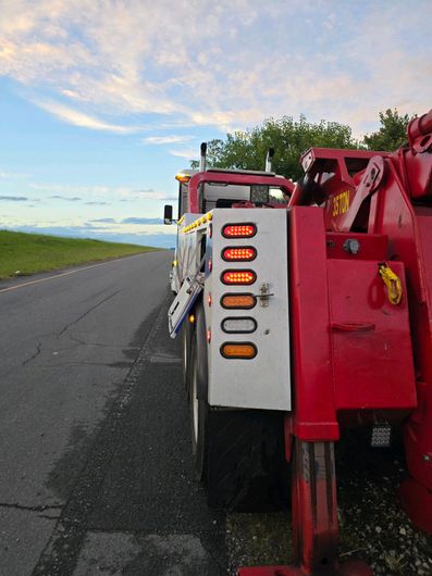 A red tow truck is parked on the side of the road