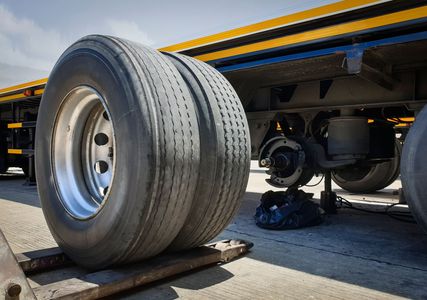 Two tires are stacked on top of each other on a truck.