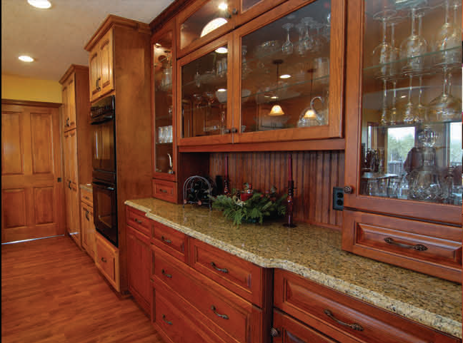Kitchen with wooden cabinets, granite countertops, and glass-door display cabinets.