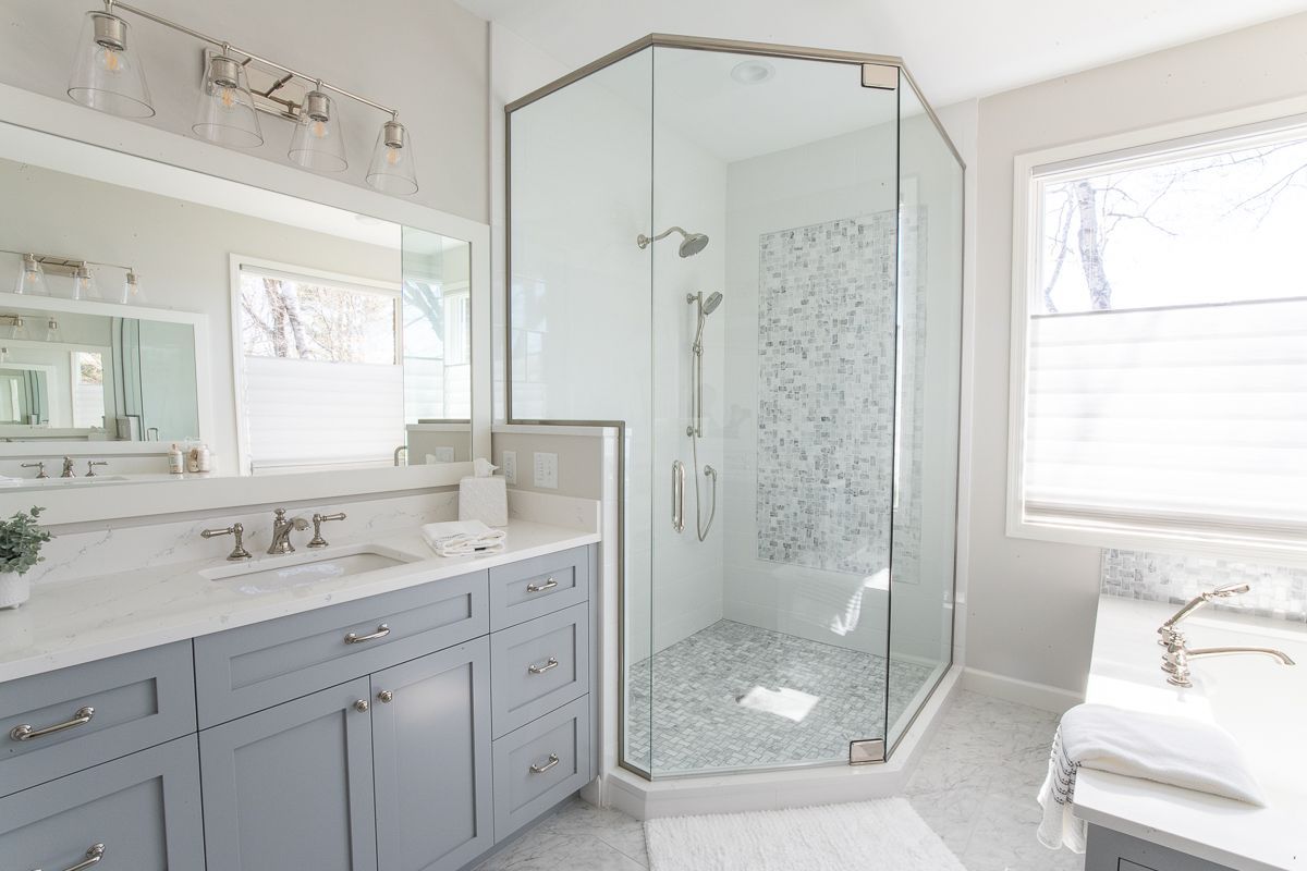 A Bathroom with A Walk in Shower , Sink and Mirror.