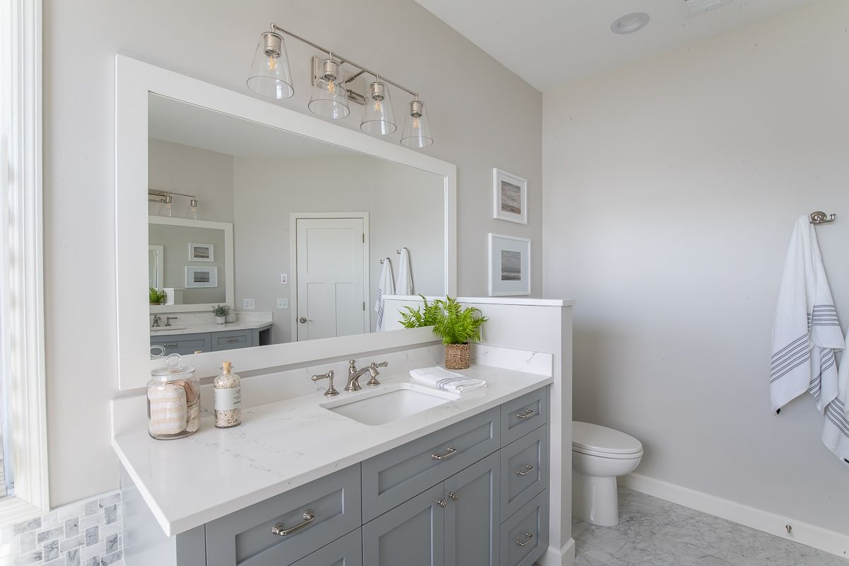 A Bathroom with A Sink , Toilet , and Mirror.